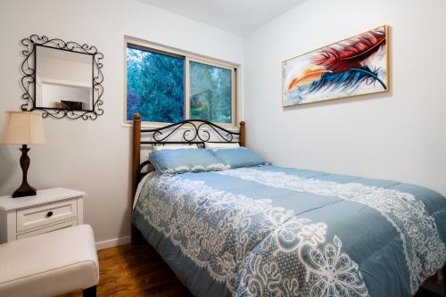 a bedroom with a bed and a mirror and a chair at NorthVAN nature living home in North Vancouver