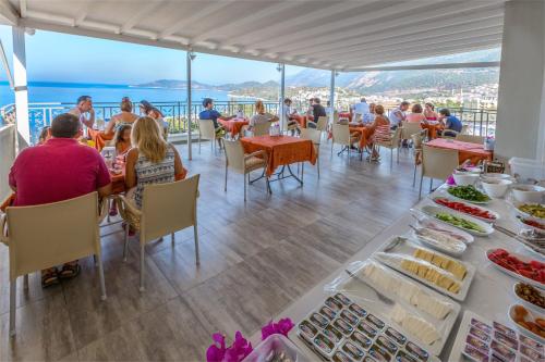 um grupo de pessoas sentadas à mesa com comida em Defne Hotel em Kas