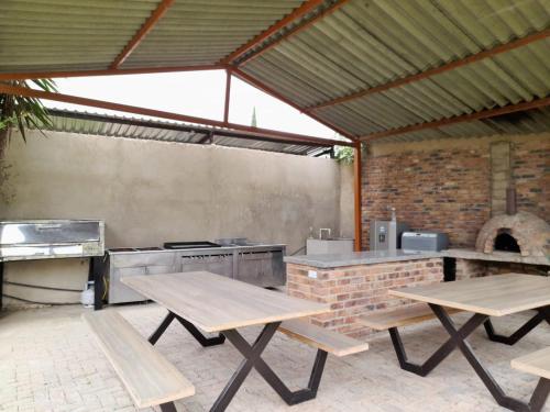 une cuisine extérieure avec des tables de pique-nique et un grill dans l'établissement Reserva de Santa Ines, à Tibasosa
