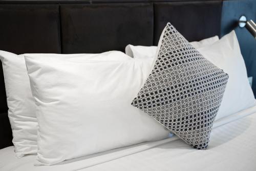a cluster of white pillows on a bed at Adelaide Rockford in Adelaide