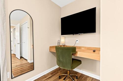 a mirror in a room with a desk and a green chair at Newly Renovated Flat near Downtown Roseville in Roseville