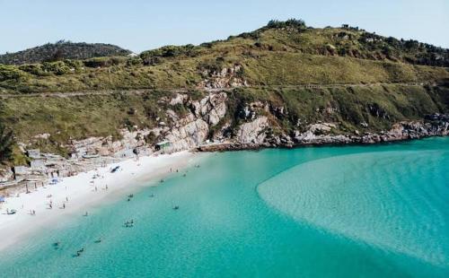 una vista aérea de una playa con gente en el agua en Casa de Praia, en Arraial do Cabo