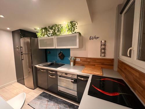 ボワ・コロンブにあるReflets la Défense-Paris - Wifi - Tout équipé - Self Checkinの冷蔵庫とコンロ付きのキッチン トップオーブン