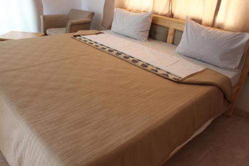 a large bed with two pillows on top of it at Pelican Residence in Fajara