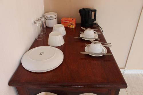 a wooden table with plates and cups on it at Pelican Residence in Fajara