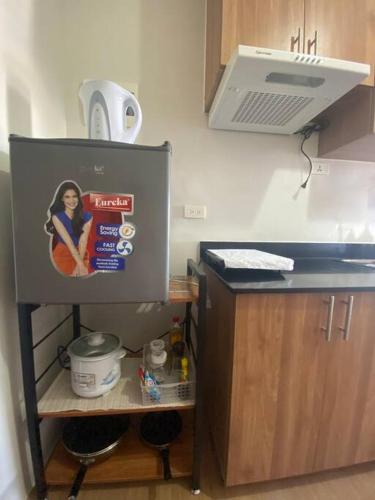 a kitchen with a refrigerator with a picture on it at Eve's Condo in Cagayan de Oro