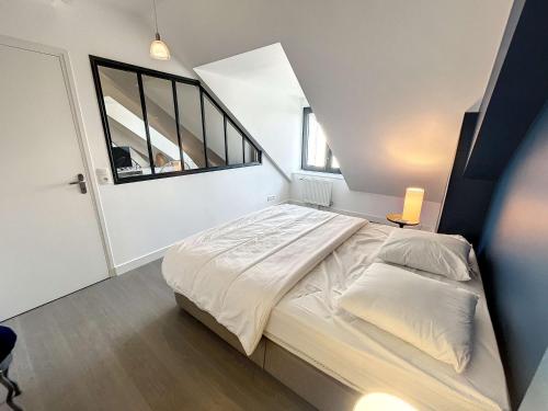 um quarto com uma cama e uma grande janela em Appartement Granville, 3 pièces, 4 personnes - FR-1-361-377 em Granville