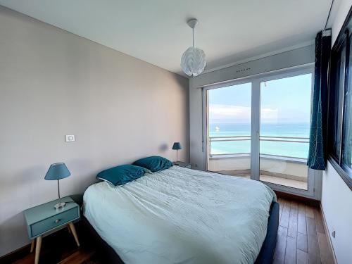 ein Schlafzimmer mit einem Bett mit Blick auf das Meer in der Unterkunft Charmant T2 en front de mer, 4 pers., ascenseur, garage, Wi-Fi - FR-1-361-383 in Granville