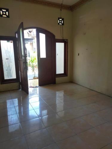 ein leeres Zimmer mit Türen und Fliesenboden in der Unterkunft banyu urip kidul regency in Surabaya