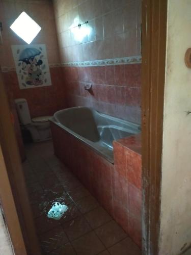 banyu urip kidul regency في سورابايا: حمام مع حوض استحمام ومرحاض