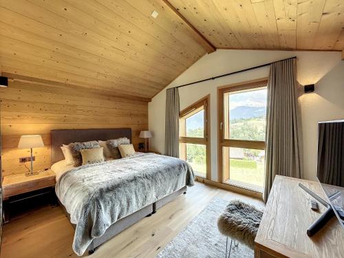 コンブルーにあるChalet de Luxe 6 Chambres avec Piscine et Bien-Être à Combloux - FR-1-560-107のベッドと大きな窓のある寝室