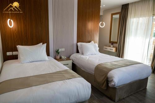 a hotel room with two beds and a mirror at Golden palm sunrise inn in Cairo