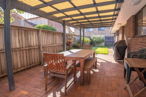 an outdoor patio with a wooden table and chairs at McKinnon on the Bay in East Ballina