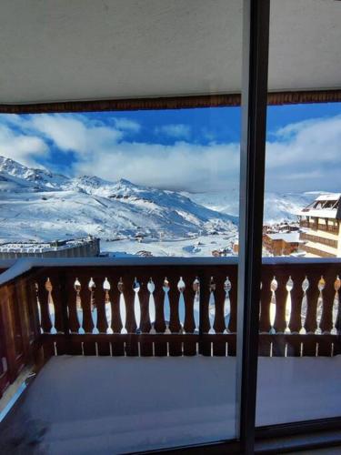 a view of a snow covered mountain from a window at Dome De Polset Condo by AlpStays in Val Thorens