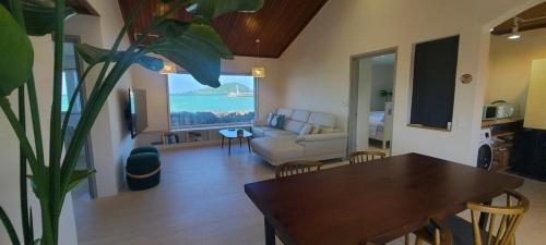a living room with a table and a couch at Hey Day Jeju in Jeju