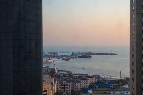 a view of the ocean from a city with buildings at Wish you like Hotel in Qingdao