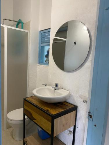 y baño con lavabo y espejo. en RAPSoDIA HOSTEL, en Villa de Leyva