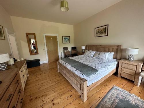a bedroom with a large bed and a wooden floor at Game of Thrones base at the Flax Mill in Coleraine