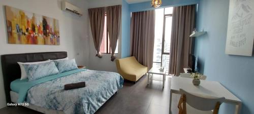 a bedroom with a bed and a desk with a chair at Maya empire studio in Kampong Bukit Lanjan