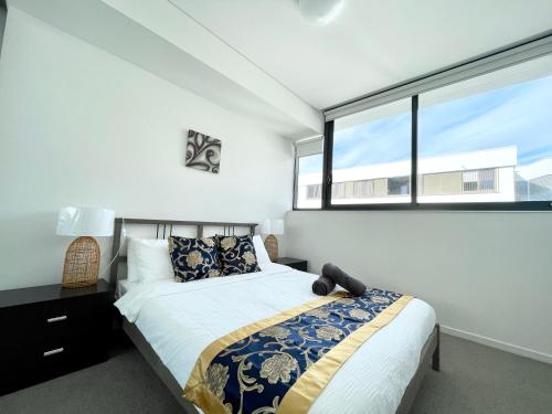 a bedroom with a bed and a large window at Spacious cozy2BR close to OlympicPark free carpark in Sydney