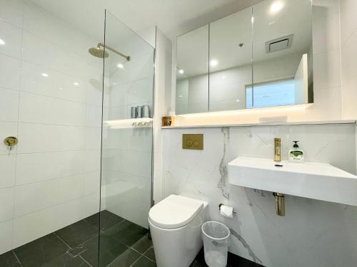 a bathroom with a toilet and a sink and a shower at Spacious cozy2BR close to OlympicPark free carpark in Sydney