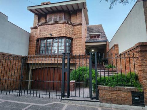 a brick house with a gate in front of it at Viajar y sentirse en casa! in Mendoza