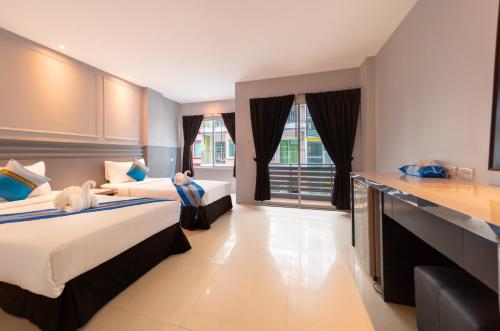 a hotel room with two beds and a kitchen at FunDee Boutique Hotel in Patong Beach