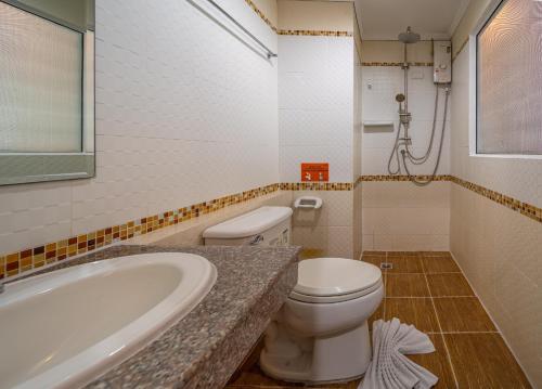 a bathroom with a toilet and a sink and a tub at FunDee Boutique Hotel in Patong Beach