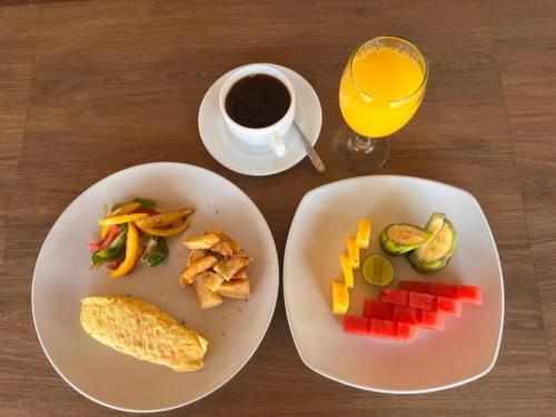 une table avec deux assiettes de nourriture et une tasse de café dans l'établissement Q'Pelagos Sunset Bungalow, à Gili Trawangan