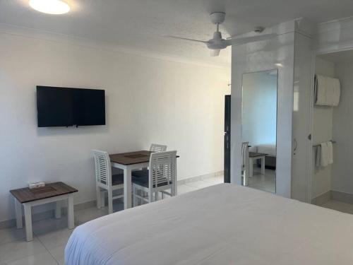 a bedroom with a bed and a table and a tv at Superior Studio - Unit 4 in Emu Park