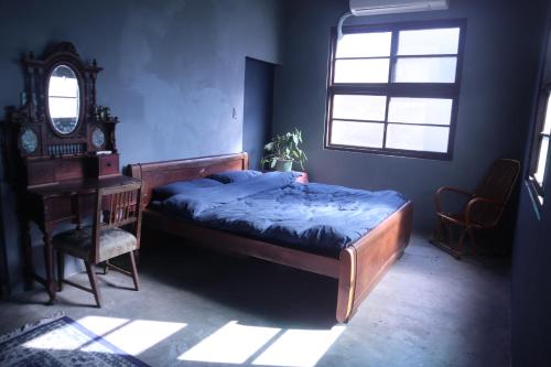 a bedroom with a bed and a desk and a window at Everythingsoup in Changhua City