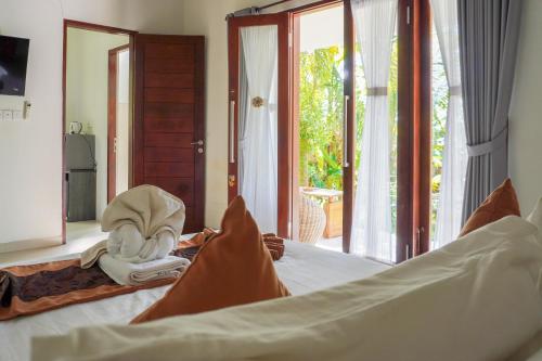 a bedroom with a bed and a door to a patio at Arya Resort Nusa Penida in Nusa Penida