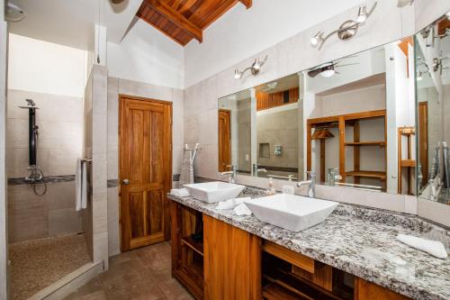 baño con 2 lavabos y espejo grande en Alta Vista Villas Vacation Rentals, en Manuel Antonio