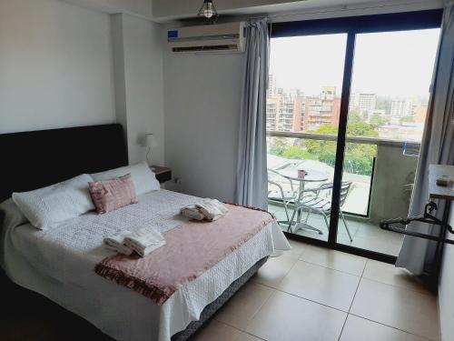 1 dormitorio con 1 cama con 2 toallas en Rouse en San Miguel de Tucumán