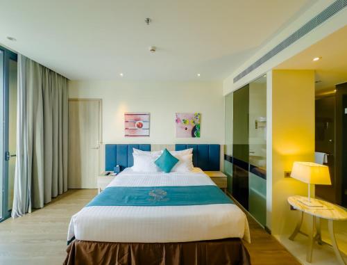 a bedroom with a large bed with blue accents at The Art Nest Hotel Nha Trang in Nha Trang