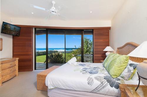a bedroom with a bed with a view of the ocean at Portofino in Lennox Head