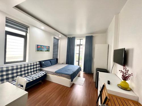 Camera con letto, divano e TV. di Daisy homestay & apartment a Hai Phong