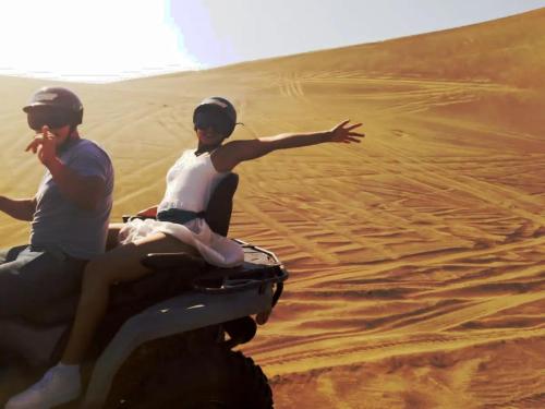 un hombre y una mujer montados en un camello en el desierto en CASA CHACHALACAS, en Chachalacas
