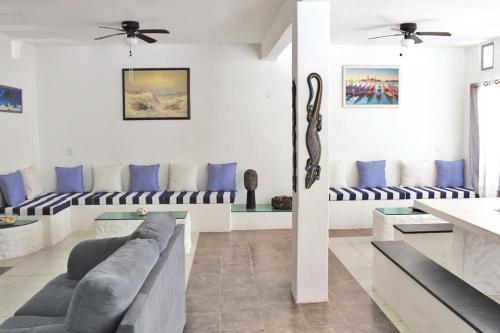 sala de estar con sofás y almohadas azules en CASA CHACHALACAS, en Chachalacas