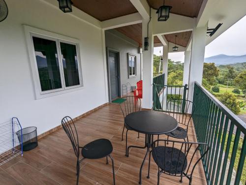 a porch with chairs and a table on a balcony at Villa with Titiwangsa Hill View in Kerling
