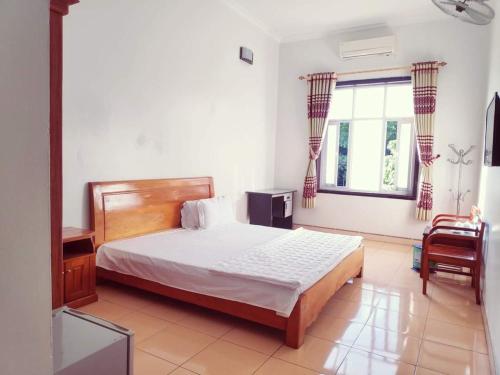 Bắc YênにあるĐỒNG TÂM HOTELのベッドと椅子と窓のある寝室