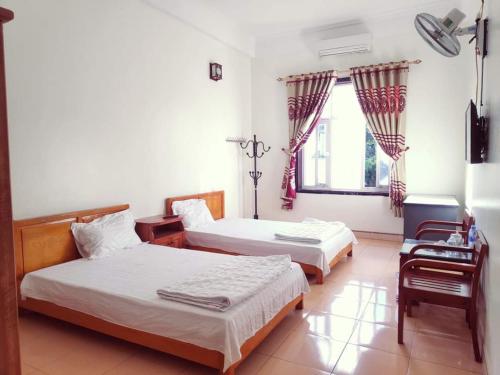 a bedroom with two beds and a window at ĐỒNG TÂM HOTEL in Bắc Yên