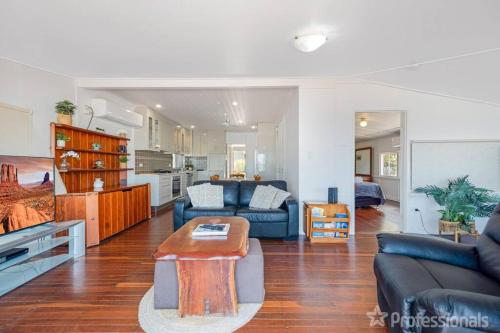a living room with a couch and a table at Beachfront Holiday Cottage in Zilzie