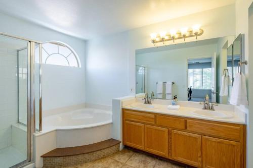 拉斯維加斯的住宿－Sin City's Hidden Gems，浴室配有2个盥洗盆、浴缸和淋浴。