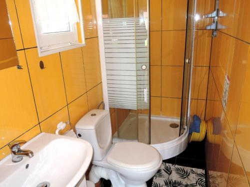 a bathroom with a toilet and a sink and a shower at Bungalow with terrace, Wrzosowo in Wrzosowo