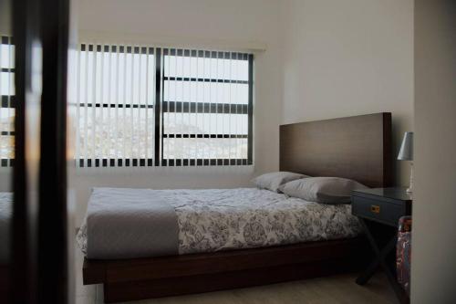 a bedroom with a bed and a large window at Macfarland Suites in Ensenada