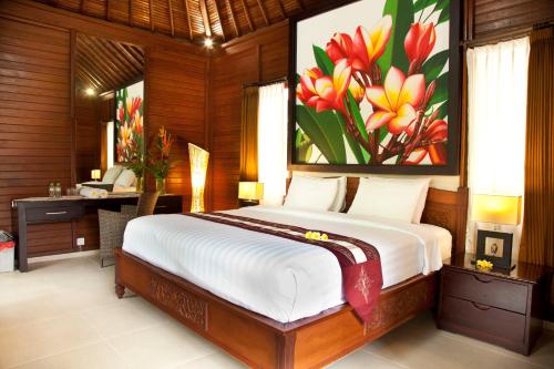 a bedroom with a bed with a painting of flowers at Jepun Bali Hotel in Kuta