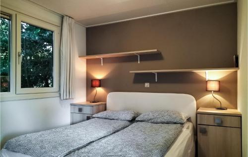 een slaapkamer met een bed met 2 lampen en een raam bij Awesome Home In Vorden With 3 Bedrooms And Wifi in Vorden