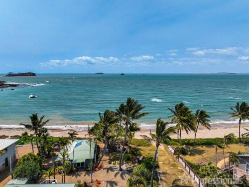 a view of a beach with palm trees and the ocean at Beachfront Holiday House in Zilzie