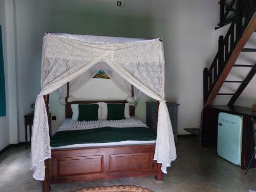 a bed with a canopy in a room at Jansen’s Bungalow Sinharaja Rainforest Retreat in Kudawe